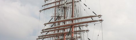 World's largest tall-ship, the Sedov, from Russia, seen being helped into Milford Marina by a tugboat, with part of the refinery in the distance.